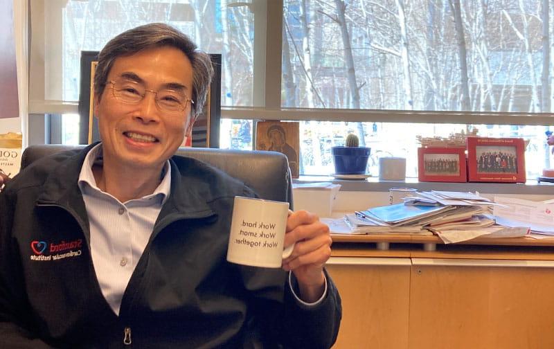 In his office, Dr. Joseph Wu’s coffee mug displays the mantra he teaches his mentees: “Work hard / Work smart / Work together.” The mug was a gift from one of those mentees. (American Heart Association)